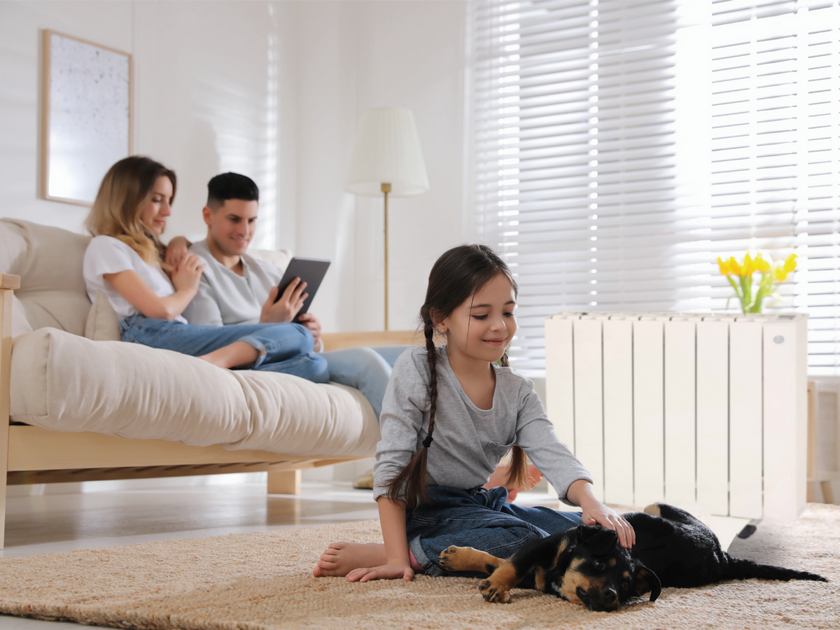 Gezin geniet van comfortabele warmte met een Batirad-speksteenradiator in de woonkamer
